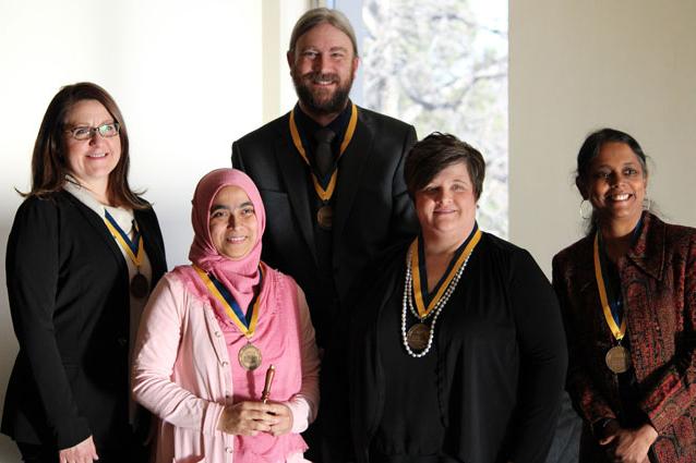 五名学生获奖，站立着，拿着奖牌